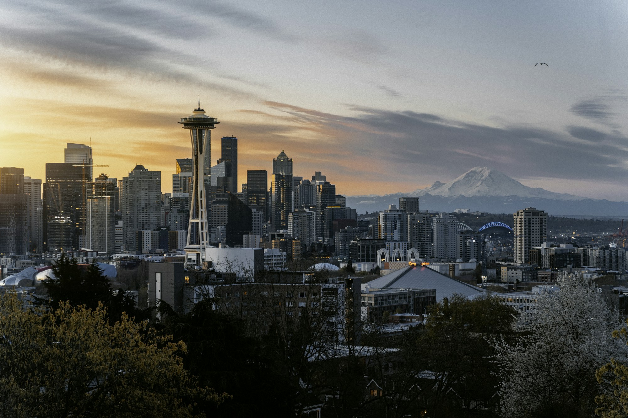 Seattle skyline and Mount Rainier under a peach-colored sunset